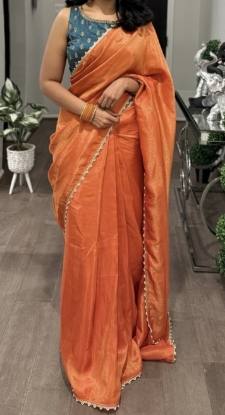Picture of Orange tissue saree with contrast peacok color blouse